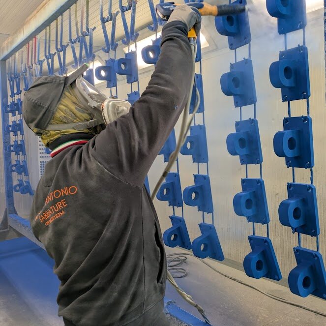 Operaio D'Antonio applica verniciatura industriale con pistola